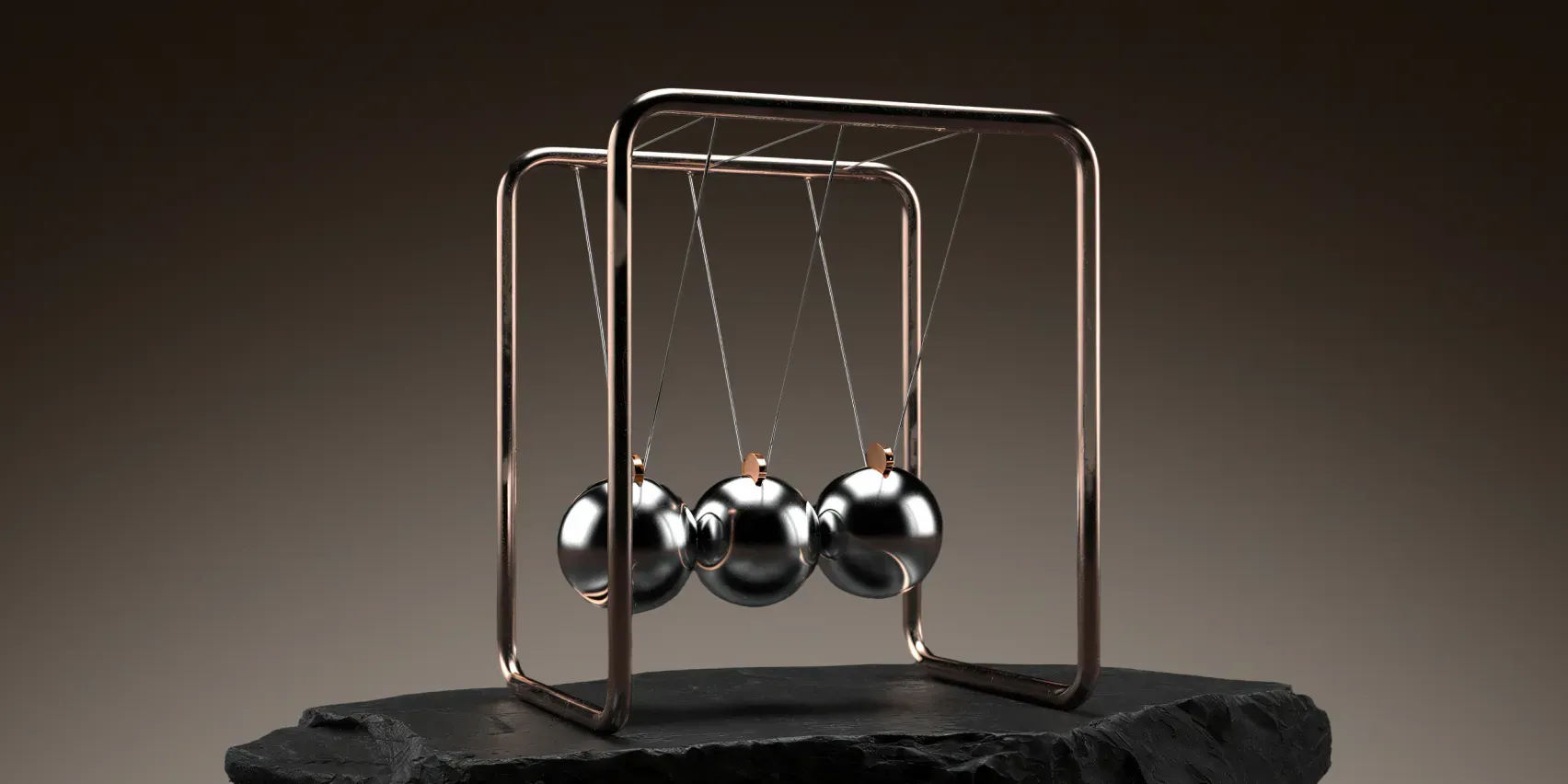 Chrome Newton's cradle with three polished steel balls hanging from a copper frame on a black slate slab, dark background.