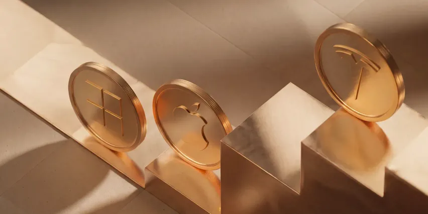 Three gold coins stamped with the Microsoft, Apple and Tesla logos, standing on beige podium steps